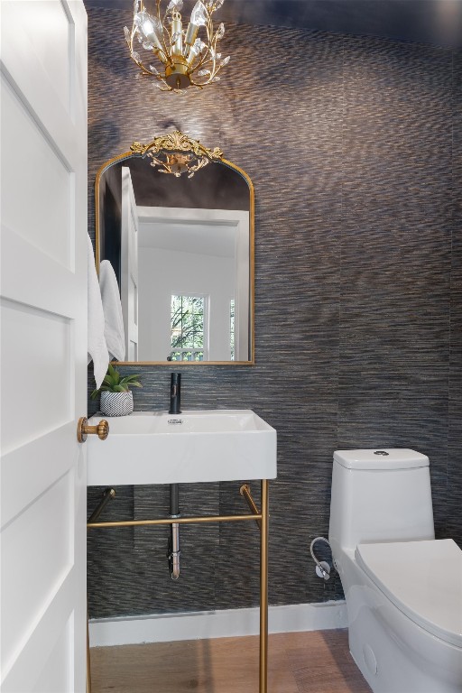 bathroom featuring sink, a chandelier, and toilet