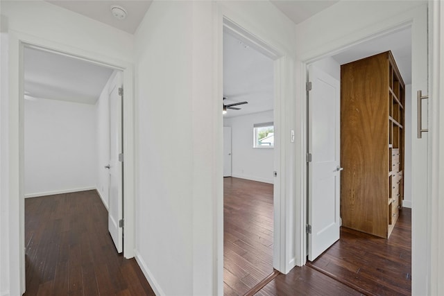 hallway with baseboards and dark wood-style flooring