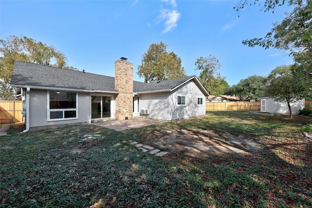 back of property featuring a lawn, a patio, a chimney, fence, and an outdoor structure