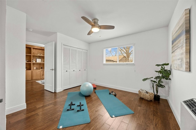 workout area with ceiling fan, dark wood finished floors, and baseboards