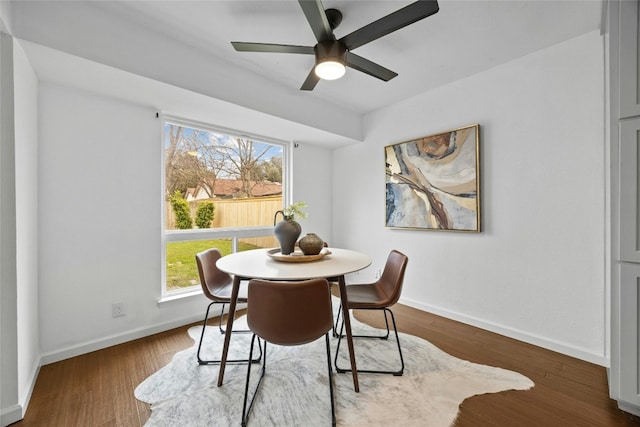 dining room featuring baseboards, dark wood finished floors, and a ceiling fan