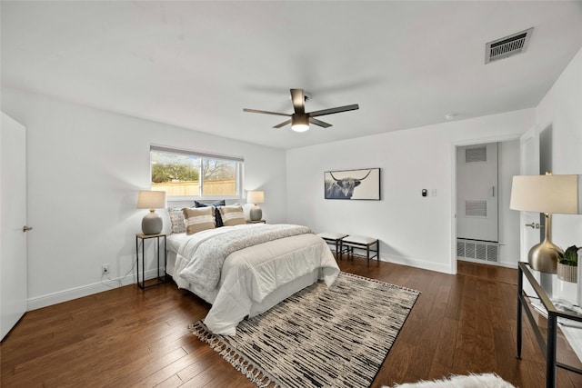 bedroom with dark wood finished floors, visible vents, and baseboards