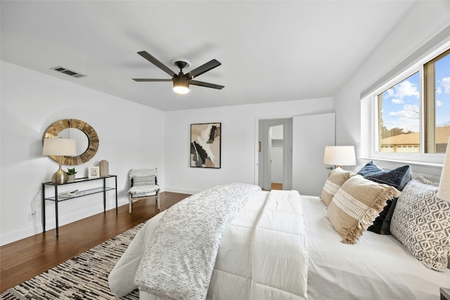 bedroom with dark wood-type flooring, visible vents, ceiling fan, and baseboards