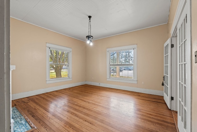 unfurnished dining area with french doors, light hardwood / wood-style flooring, and ornamental molding