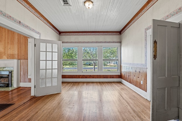 unfurnished living room with light hardwood / wood-style floors and ornamental molding