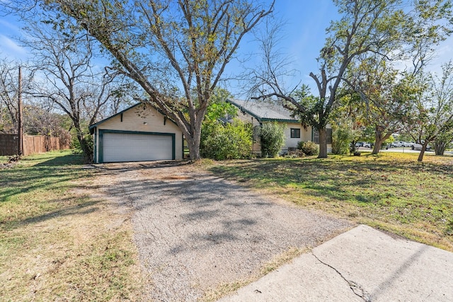 ranch-style home with a garage, an outdoor structure, and a front yard