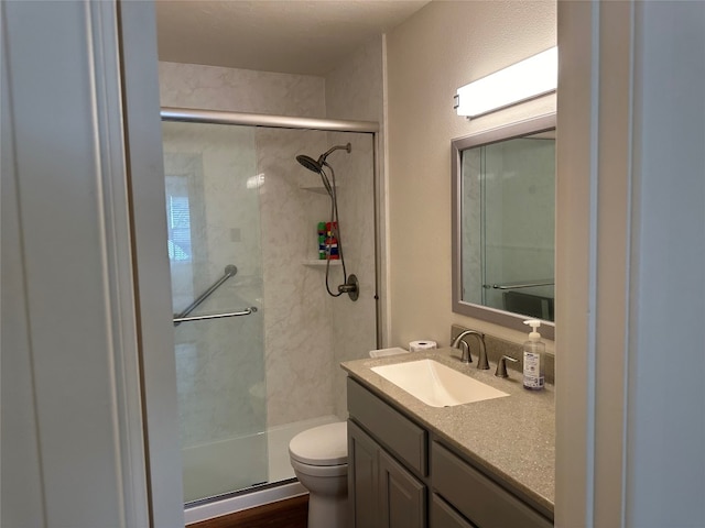 bathroom with walk in shower, hardwood / wood-style flooring, vanity, and toilet