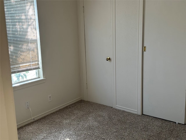 unfurnished bedroom featuring carpet floors, a closet, and multiple windows