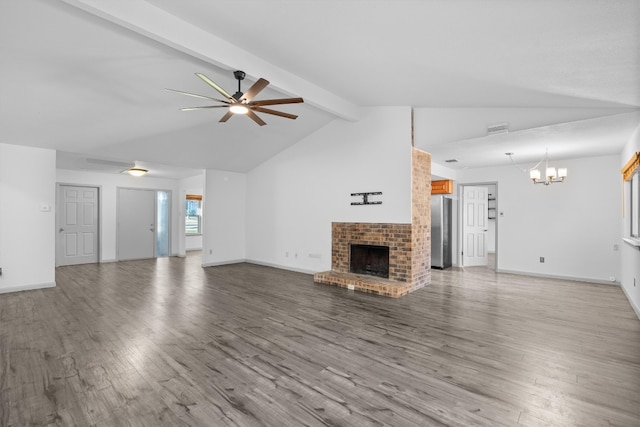 unfurnished living room featuring vaulted ceiling with beams, wood-type flooring, ceiling fan with notable chandelier, and a brick fireplace