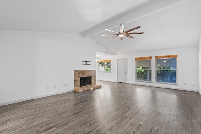 unfurnished living room featuring ceiling fan, beam ceiling, wood-type flooring, and a brick fireplace