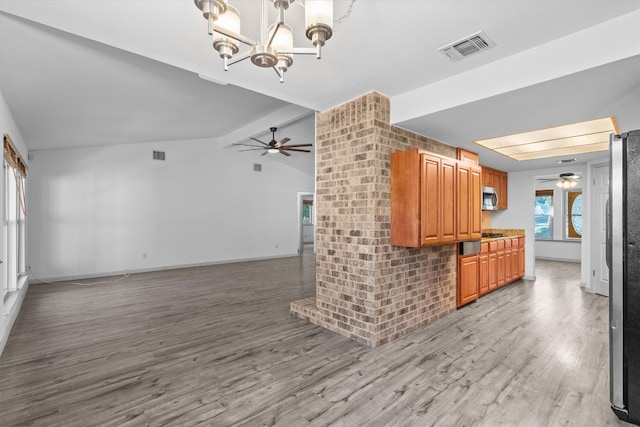 kitchen with light hardwood / wood-style floors, vaulted ceiling, and an inviting chandelier