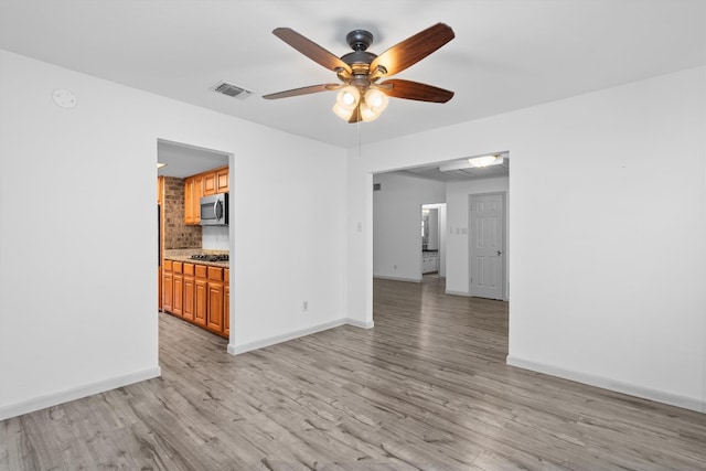 unfurnished living room with ceiling fan and light wood-type flooring