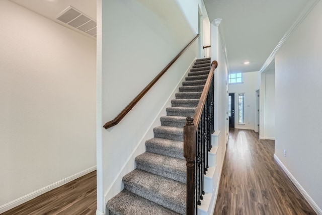 stairs featuring hardwood / wood-style floors and ornamental molding