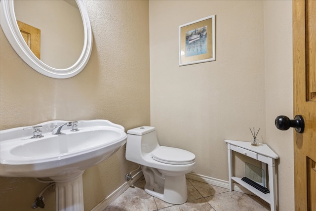 bathroom featuring sink, tile patterned flooring, and toilet