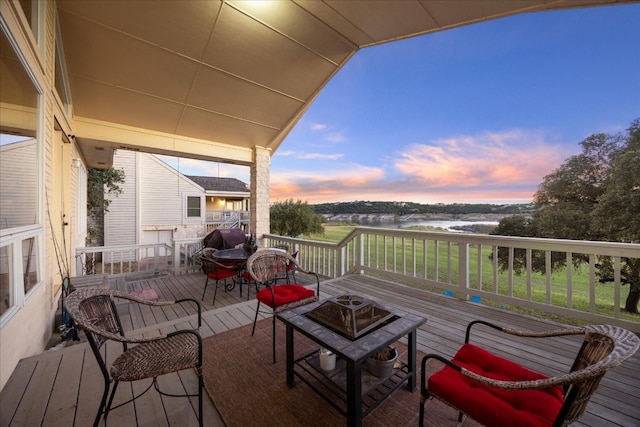 deck at dusk featuring a fire pit