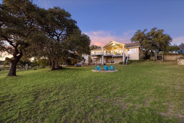 yard at dusk featuring a wooden deck