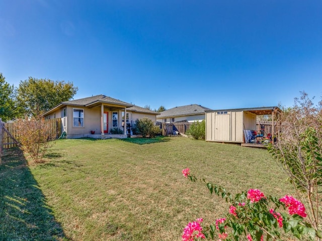back of property featuring a fenced backyard, an outdoor structure, a yard, and a storage unit