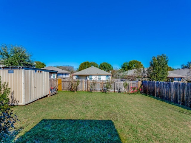 view of yard with a fenced backyard, an outbuilding, and a storage shed
