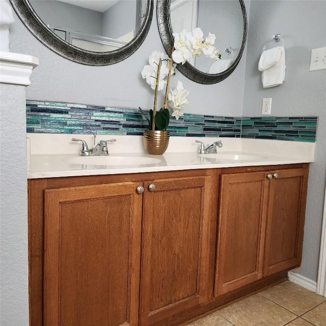bathroom featuring backsplash, double vanity, tile patterned floors, and a sink
