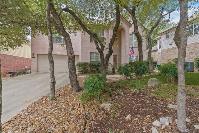 view of front of house with central air condition unit and a garage