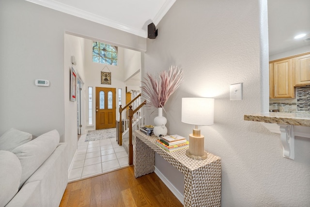 entryway featuring ornamental molding and light hardwood / wood-style flooring