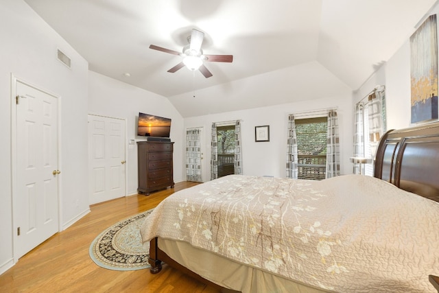 bedroom featuring hardwood / wood-style floors, vaulted ceiling, and ceiling fan