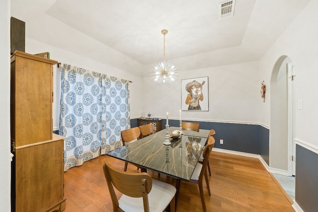 dining area with a notable chandelier and light hardwood / wood-style flooring