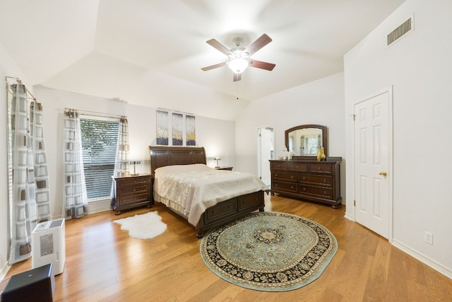 bedroom with ceiling fan, wood-type flooring, and vaulted ceiling