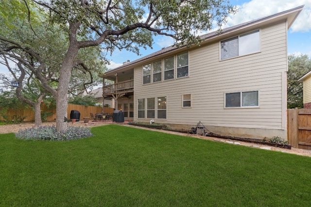 back of house with a lawn, a patio area, and a balcony