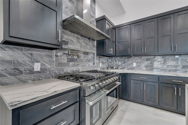 kitchen with light stone countertops, wall chimney range hood, backsplash, double oven range, and light tile patterned flooring