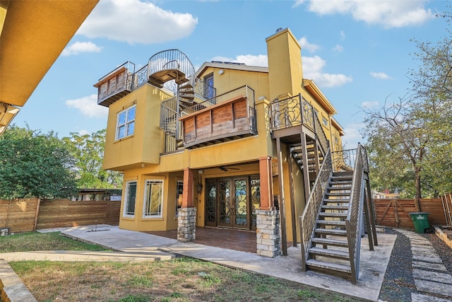 back of property featuring a balcony and french doors