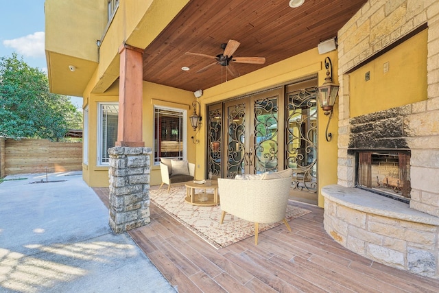 view of patio featuring an outdoor stone fireplace and ceiling fan