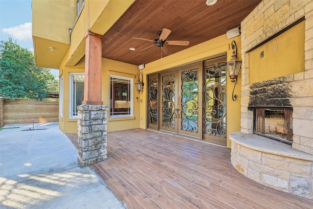 view of patio / terrace featuring an outdoor stone fireplace and ceiling fan