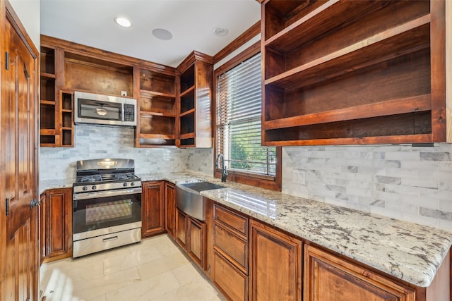 kitchen with tasteful backsplash, light stone counters, sink, and stainless steel appliances