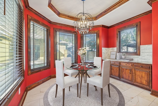 dining room featuring a chandelier, a raised ceiling, and a wealth of natural light