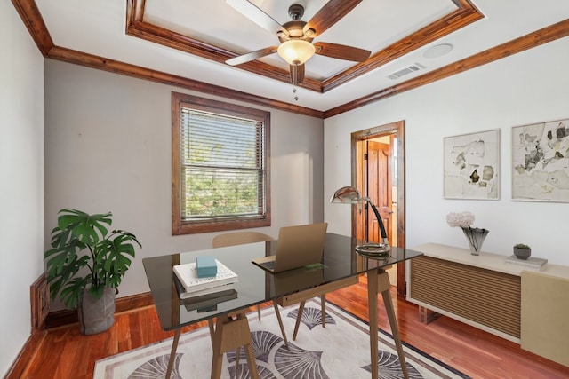 office space featuring a tray ceiling, crown molding, and hardwood / wood-style floors