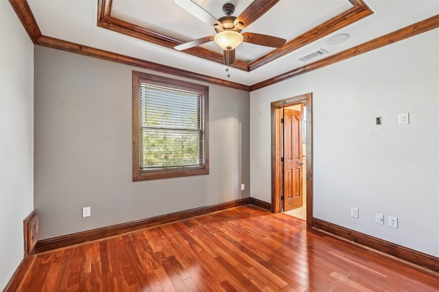 spare room featuring hardwood / wood-style floors, a raised ceiling, and crown molding