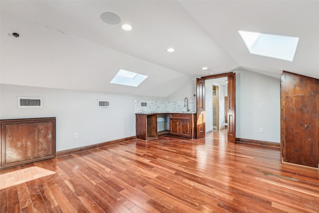 bonus room featuring wood-type flooring and lofted ceiling with skylight