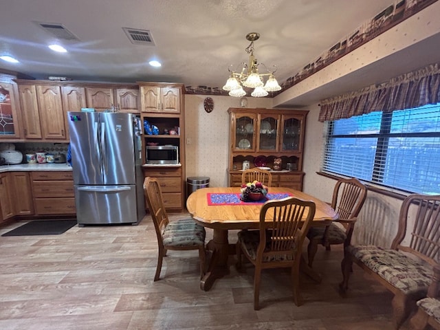 dining area featuring light hardwood / wood-style flooring and an inviting chandelier