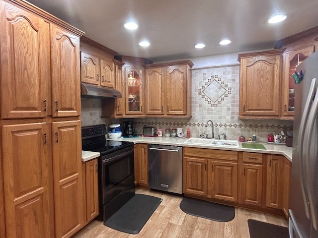 kitchen featuring decorative backsplash, light hardwood / wood-style floors, sink, and appliances with stainless steel finishes