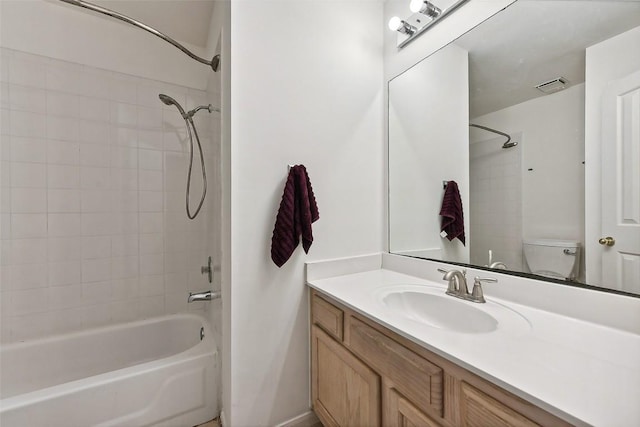 full bathroom with vanity, toilet, and tiled shower / bath