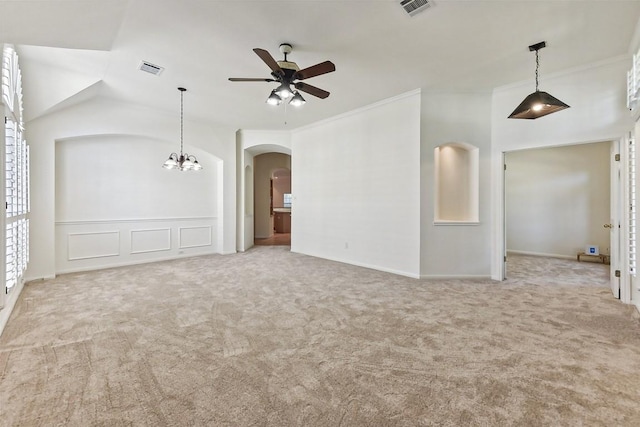 carpeted empty room with vaulted ceiling, crown molding, and ceiling fan with notable chandelier