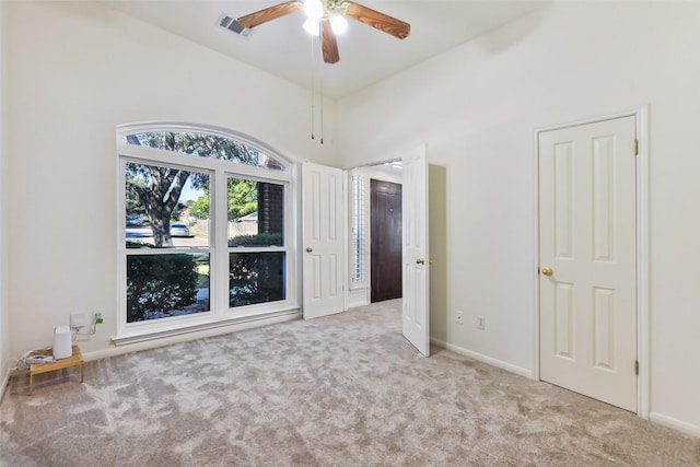 spare room with light carpet, ceiling fan, and vaulted ceiling