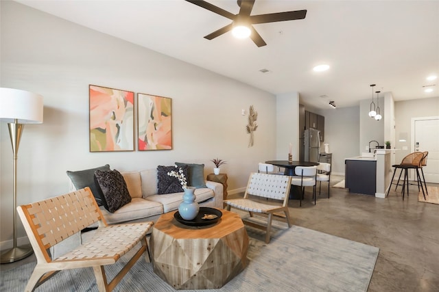 living room with concrete flooring, sink, and ceiling fan