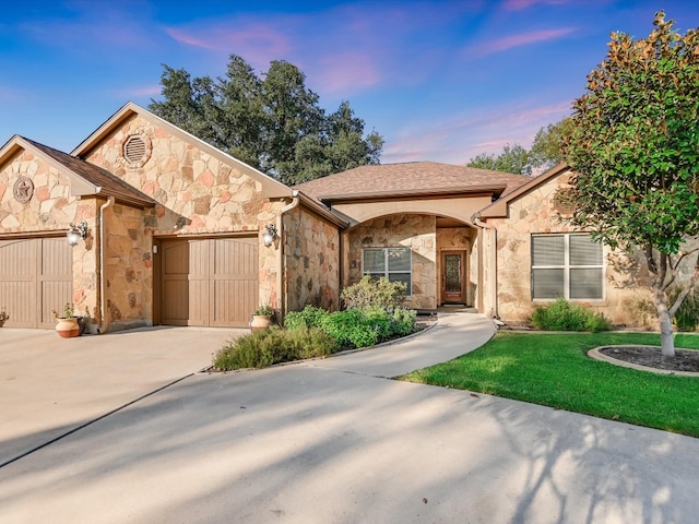 view of front of house featuring a garage and a lawn