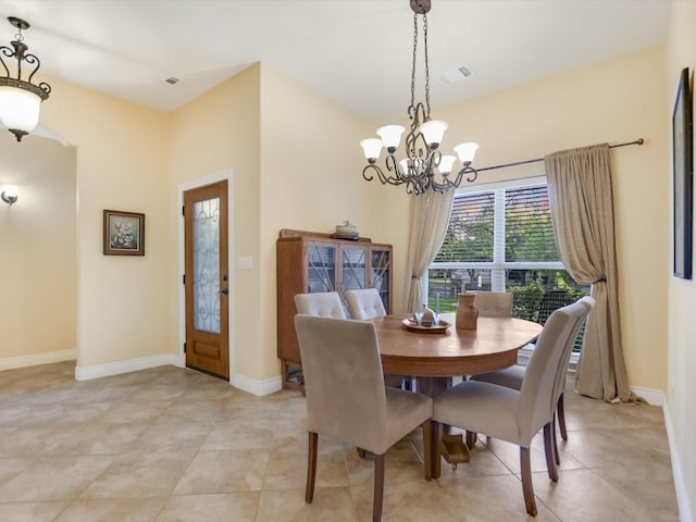 dining space featuring light tile patterned floors and an inviting chandelier