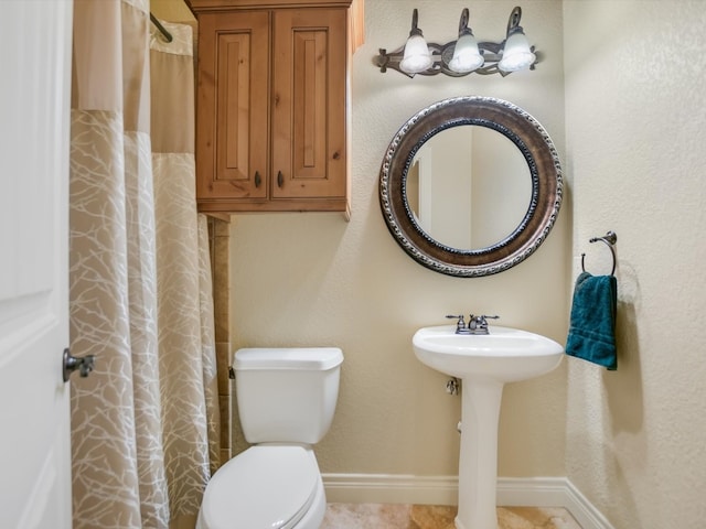 bathroom featuring a shower with curtain, sink, and toilet