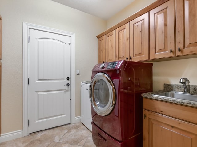 washroom with cabinets, light tile patterned floors, washing machine and clothes dryer, and sink