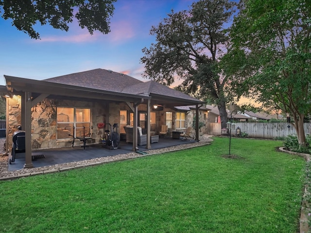 yard at dusk featuring an outdoor living space and a patio