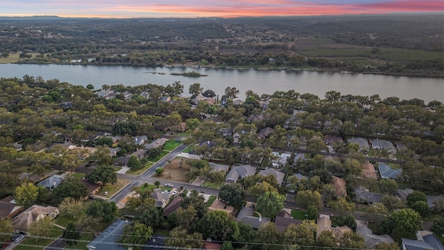 aerial view at dusk featuring a water view